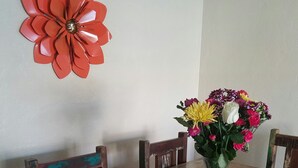 A wooden dining table with a vase of flowers on a round tray. - Three Bedrooms Two Baths sleeps 6 - Walking distance to Downtown Paso Robles (Paso Robles)