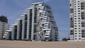 A modern high-rise building with multiple balconies and a unique angular design.