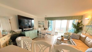 A spacious living room with a television, dining area, and a sofa.