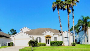 A single-story house with a front entrance, a garage, and a well-maintained lawn. - Immaculate Spacious Villa.No rear neighbors,Games Room,office,Large pool,hot spa (Davenport)