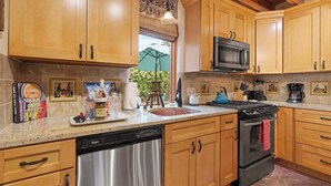 A kitchen with wooden cabinets, a microwave, a stove, and a dishwasher.