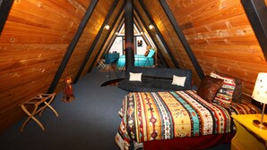 A cozy attic bedroom with a bed, a small desk, and a chair. - RIVER IN YOUR FRONT YARD!/Suspended Fireplace/Perfect for Families & Groups/PETS (Red River)