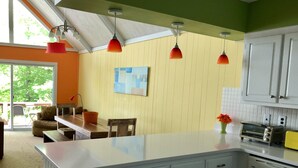 A kitchen with a large island, white cabinets, and a red pendant light. - Lakefront 🛶 • Spa ♨️ • Firepit 🔥 • Boating 🚣‍♂️ • Game Rm 🎮 • Fishing 🎣 • Sunsets 🌅 (Poconos Lake)