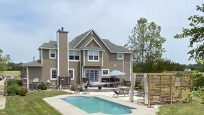 A two-story house with a swimming pool, outdoor furniture, and a wooden fence. - Family vacation retreat w/ In-ground Pool with private Chesapeake Bay access! (Cape Charles)