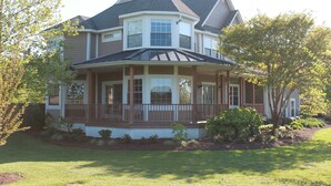 A two-story house with a wrap-around porch, a bay window, and a gabled roof. - Family vacation retreat w/ In-ground Pool with private Chesapeake Bay access! (Cape Charles)