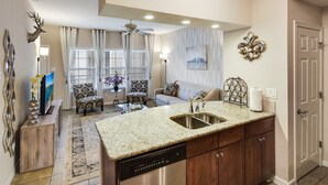 A modern kitchen with a stainless steel dishwasher, a granite countertop, and wooden cabinets. - Lake View - Gorgeous Lake Travis Island Condo!!! (Lago Vista)