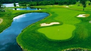 A golf course with water hazards, sand bunkers, and a clear path for play.