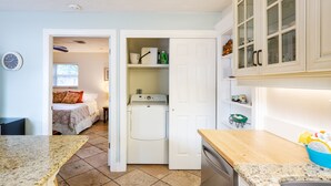 A compact kitchen with a washing machine, a wooden countertop, and a sink. - Vanderbilt Beach (Naples)