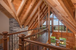A wooden interior with a stone wall and a wooden staircase.