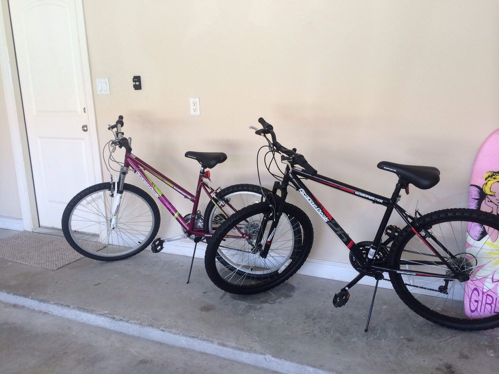 Two bicycles parked against a wall.