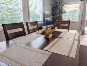 A dining table with a placemat, a bowl of snacks, and two chairs. - Spacious Home Short Walk to Disneyland (Anaheim)