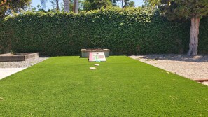 Relax in a serene outdoor space surrounded by lush greenery and a decorative feature.