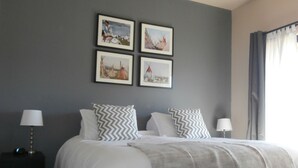 A bedroom with a bed, two nightstands, a ceiling fan, and four framed pictures on the wall. - Luxurious, Upscale Townhome In Sedona. Super clean, gourmet kitchen, comfy beds! (Sedona)