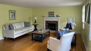 Una sala de estar con chimenea, un sofá, una mesa de centro y una silla.
