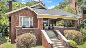A two-story brick house with a covered porch, a front yard, and a staircase leading to the entrance. - Fabulous Location Updated 3bd/2bth Home (Birmingham)