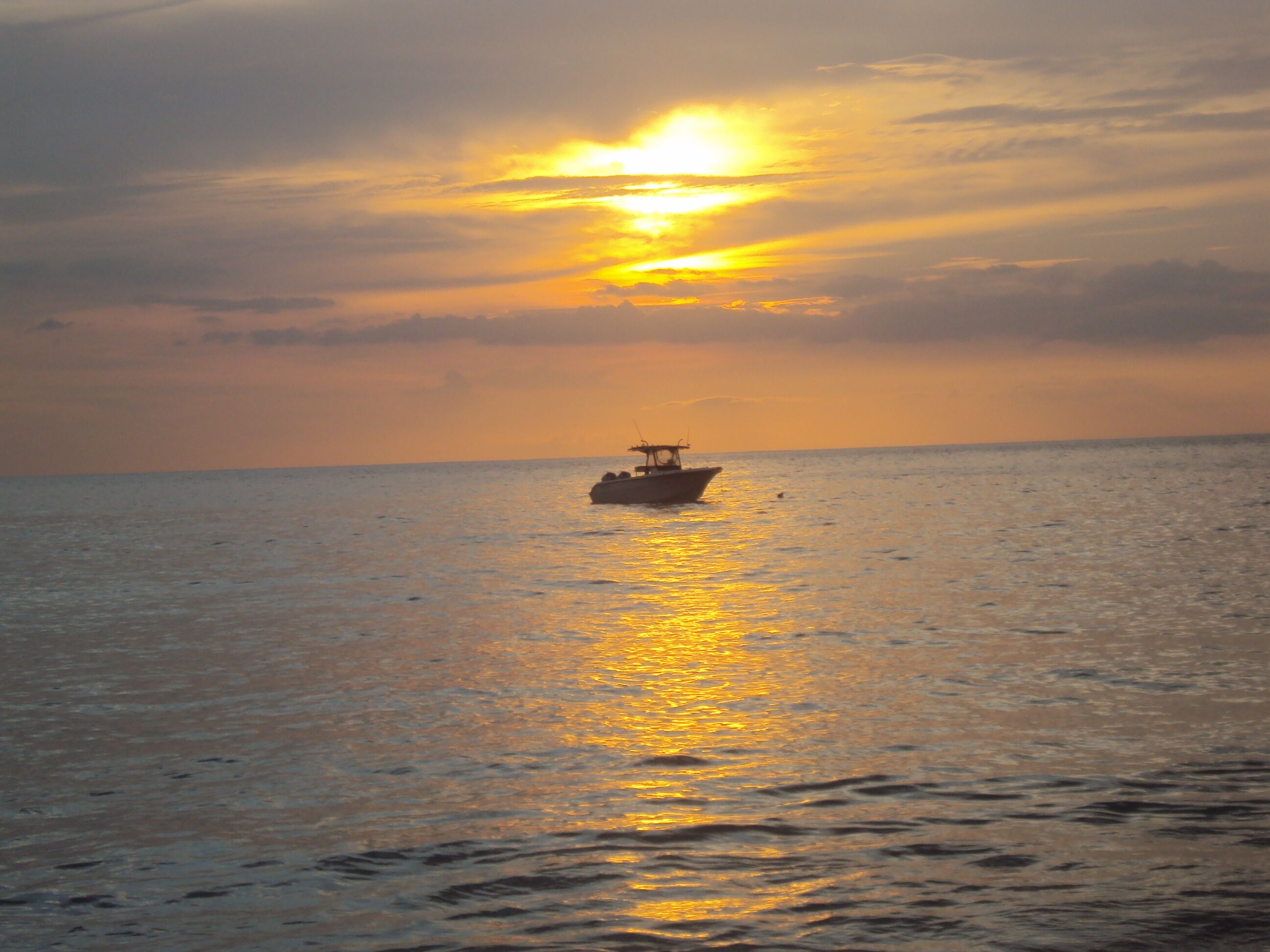 A boat on calm water during sunset.