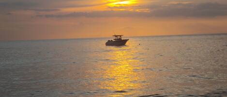 A boat on calm water during sunset.
