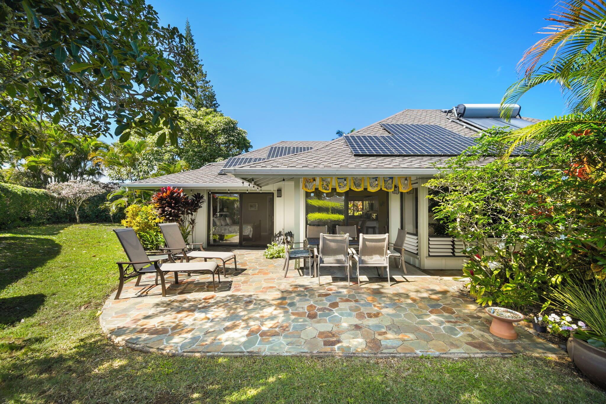 A house with a patio area featuring outdoor furniture and a stone floor.