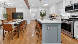 A modern kitchen with white cabinets, stainless steel appliances, and a central island.