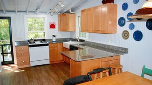 Eine Küche mit Holdekor, einer Arbeitsplatte aus Granit und einem Essbereich mit Tisch und Stühlen.