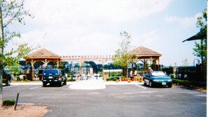 A parking area with two cars, a gazebo, and a covered walkway. - Gorgeous Home in OC: Pools, Kayak, Fishing Pier, 5min to beach & Boardwalk, Golf (Berlin)