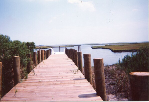 A wooden boardwalk leading to a bridge over water.