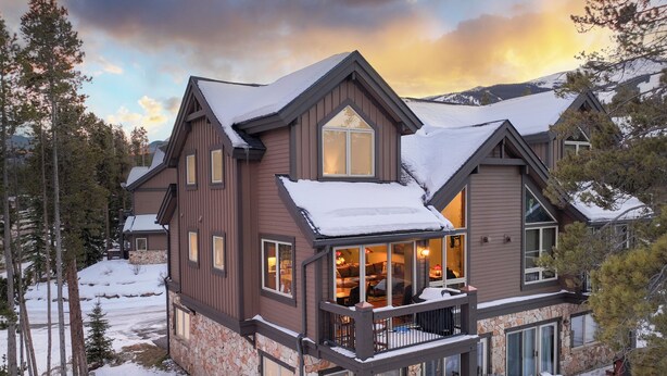 A large, multi-story lodge with a stone foundation, a hot tub, and a deck area. - Slopeside Saddlewood: True Ski-in/Out, Private Hot Tub, Grill, Shuttle (Breckenridge)