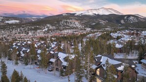 A snow-covered mountain town with modern houses and a ski resort in the background. - Slopeside Saddlewood: True Ski-in/Out, Private Hot Tub, Grill, Shuttle (Breckenridge)