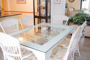 Enjoy meals in this cozy dining area with a glass-top table and comfortable wicker chairs.