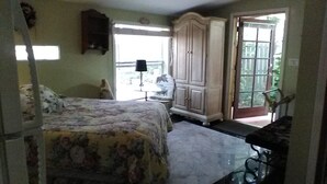 Een slaapkamer met een bed, een kledingkast, een bureau en een stoel.