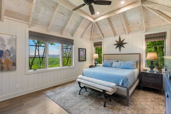 Un dormitorio con una cama grande, un ventilador de techo y una decoración con estrellas en la pared.