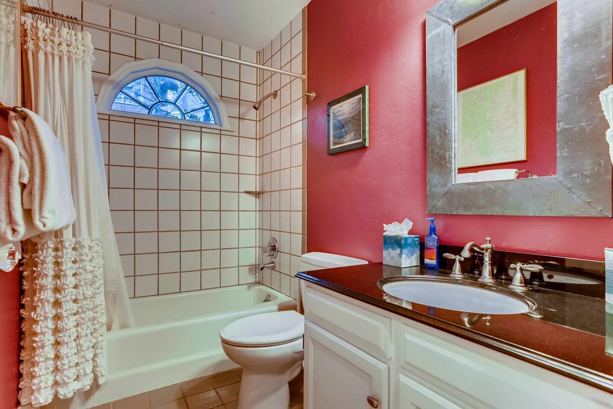 A bathroom with a bathtub, toilet, and sink.