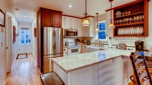 A modern kitchen with stainless steel appliances, a central island, and wooden cabinetry.