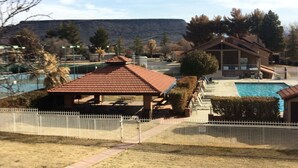 Zona residencial con piscina, un quiosco y una montaña al fondo.