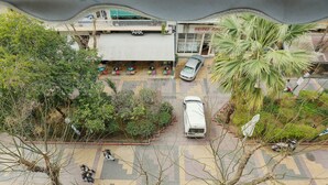 An outdoor area with a car parked in front of a building labeled "ARK". - Cosy & Bright 2 Bedroom Apartment in Koukaki (Athens)