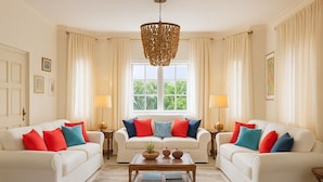 A spacious living room with two white sofas, a wooden coffee table, and a large window with curtains. - Villa Serenity · 5BR Fully Staffed Oceanview Villa w/ Chef, Pool & Beach Access (Rio Nuevo bay)