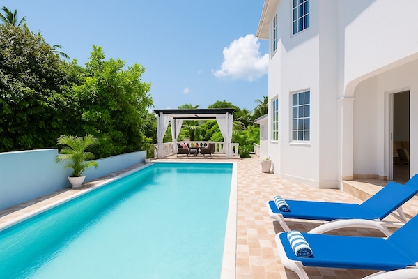 Een buitenzwembad en ligstoelen