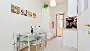 A modern kitchen with white cabinets, a built-in oven, and a stainless steel range hood.