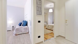 A bedroom with a bed, bedside table, and a wall with a motivational quote.