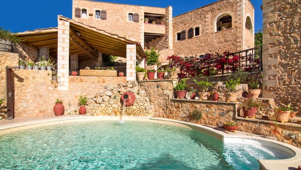 A stone building with a pool, potted plants, and a stone wall. - Purple villa Malotira - 1 bedroom -veranda -roof terrace - mountain and sea view (Chania)