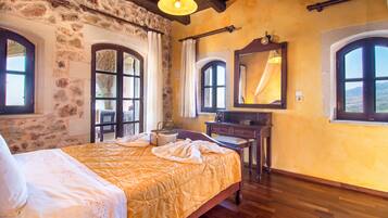 A room with a bed, a dresser, and two windows with curtains.