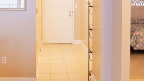 A hallway with a door at the end, a radiator, and a framed picture on the wall. - Oceanfront_Spacious_View the Sunrise_ Family Friendly & Quiet Building (Myrtle Beach)