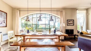 A dining area with a wooden table, benches, and pendant lights. - Unique house with air con, wine country, pool 18x5, close Avignon (Cairanne)