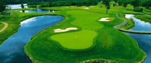 Ein Golfplatz mit Wasserhindernissen, Sandbunkern und einer freizügigen Spielbahn.
