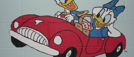 A cartoon character in a red car with a steering wheel.