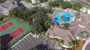 An aerial view of a residential area with a swimming pool, tennis courts, and a parking lot. - Luxury Condo Steps to Disney, Gated Resort Perfect Location, Free Parking & WiFi (Kissimmee)