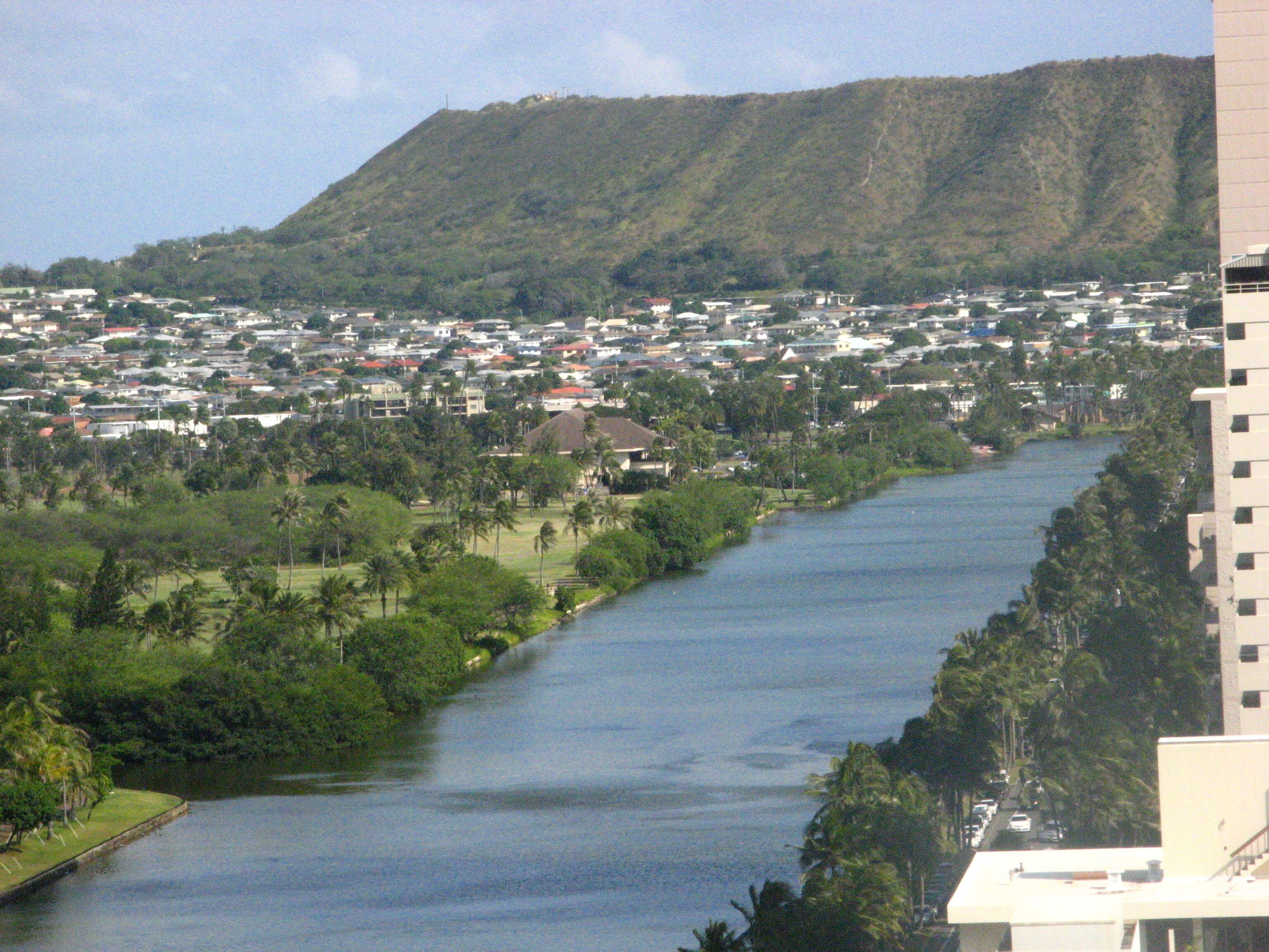 A river flowing through a town with a mountain in the background.