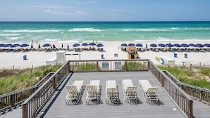 A beachside deck with sun loungers and umbrellas, overlooking the ocean.