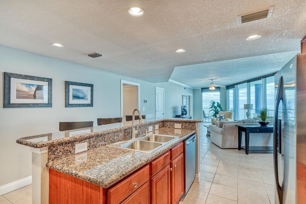 A modern kitchen with granite countertops, wooden cabinets, and a built-in dishwasher.