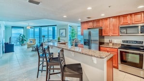 A modern kitchen with granite countertops, stainless steel appliances, and wooden cabinets.
